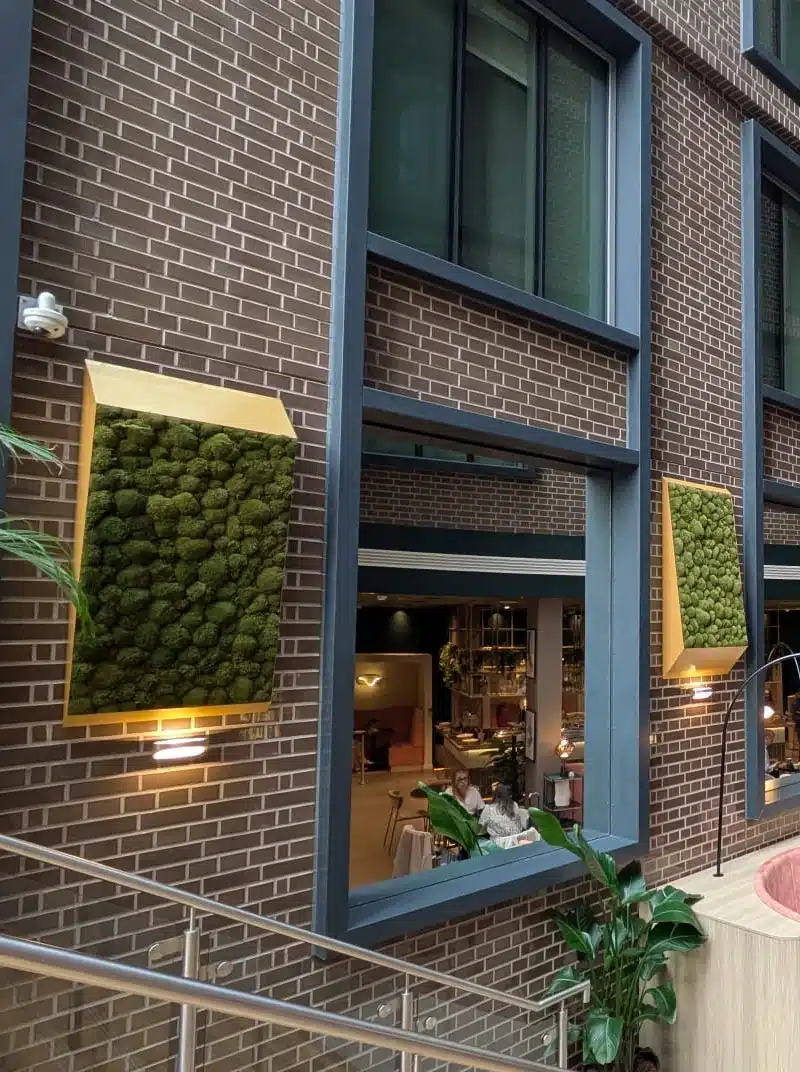Vertical moss panels on brick building exterior.