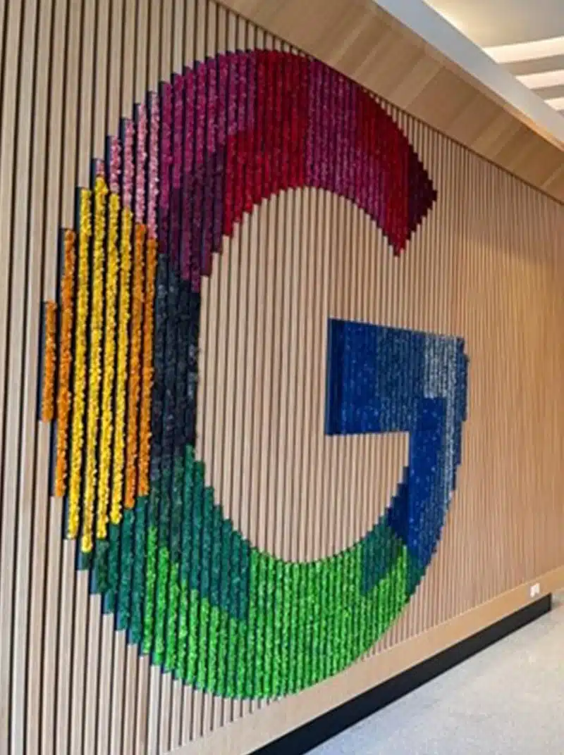 Colorful Google logo on wooden slat wall.