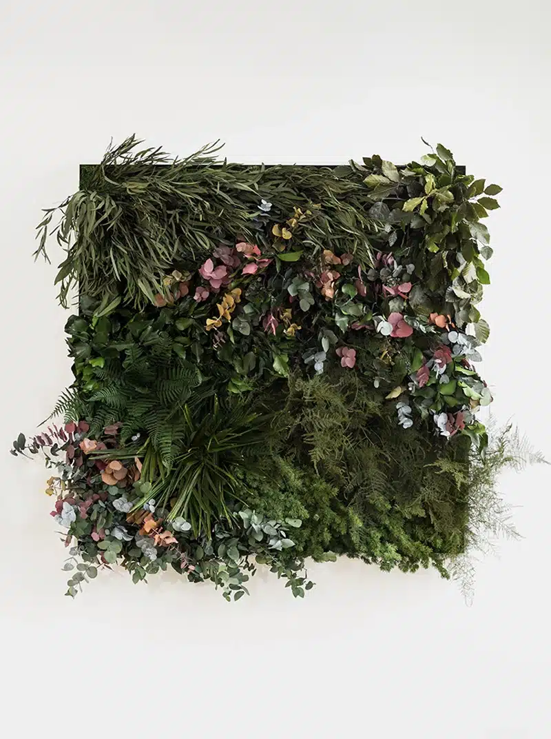 Vertical garden with diverse leafy plants and flowers.